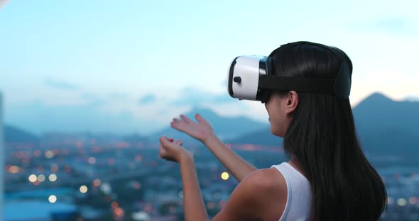 Woman watching on VR device in the evening 