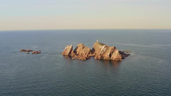 An Abandoned Lighthouse on Top of a Rocky Island at Sunrise