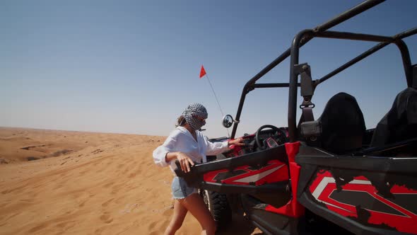 Young Woman Entering a Sand Buggy on a Desert Tour