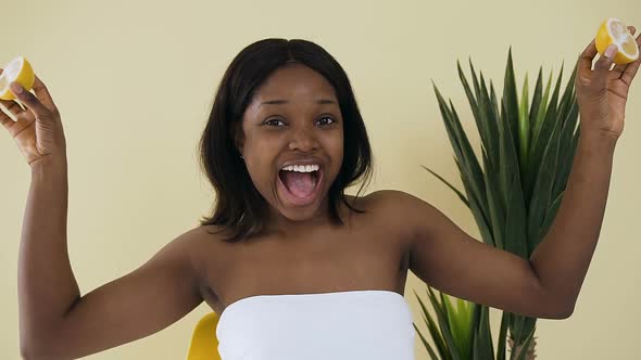 Beautiful Afro American Woman Playing with Two Slices of Lemon 