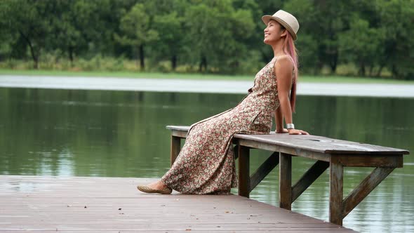 Beautiful woman sitting relax beside lake