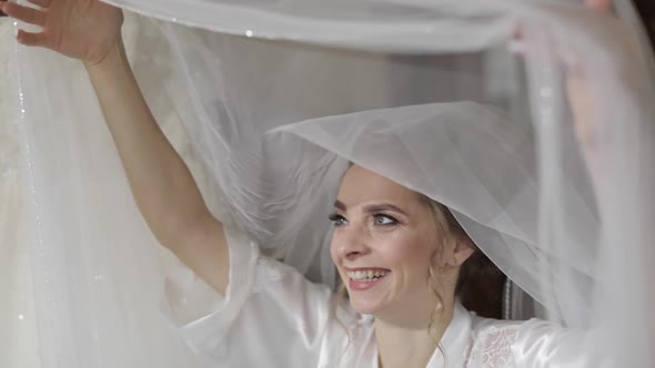 Beautiful and Lovely Bride in Night Gown Under Huge Veil. Wedding Morning