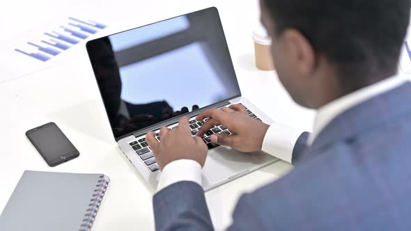 Rear View of Focused African Businessman Working on Laptop 