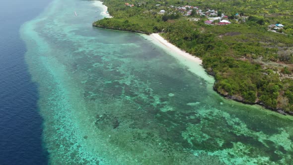 Aerial: Flying over tropical beach turquoise water coral reef, Indonesia 