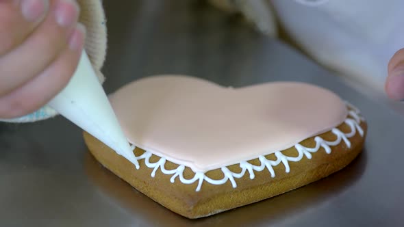 Female Hands Decorating Fresh Gingerbread Cookie