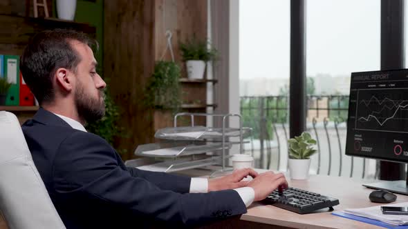 Businessman in Modern Office with Big Windows Working on the Computer