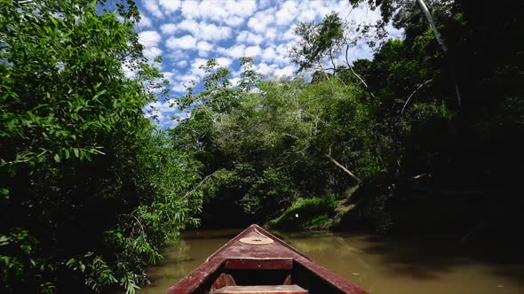 boat moving slowly through a narrow canal in amazon