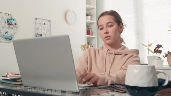 Female Student Typing on Laptop at Home