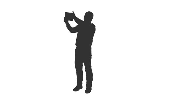 Silhouette of Male Tourist Taking Selfie with Tablet alt