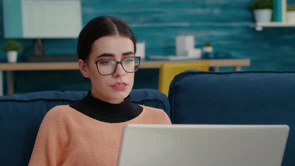 Young Adult Waving at Video Call Meeting Webcam on Couch