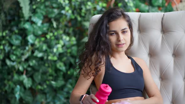 Medium Closeup Portrait of Tired Young Fitness Woman Using Towel Sitting on Couch