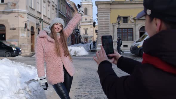 Two Young Smiling Women Travelers Bloggers Taking Photos Portrait on Mobile Phone on City Street