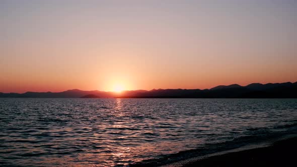 sunset view on beach with sea and mountains