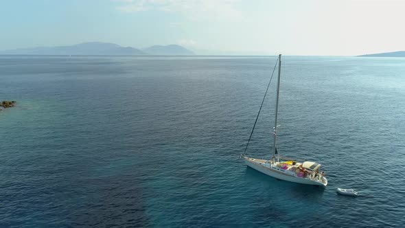 Aerial view of sailboat anchored in the mediterranean sea, Nisi, Greece.