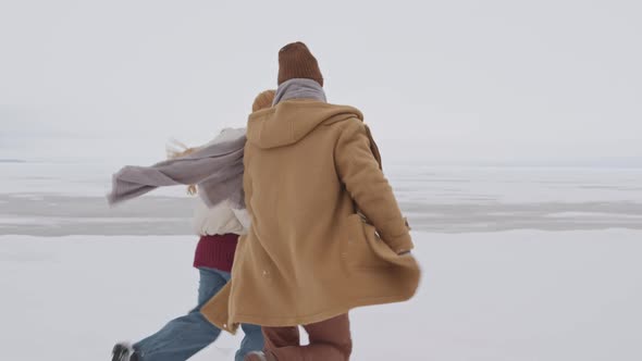 Couple in Love Running on Winter Beach