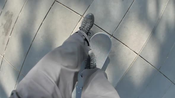 POV of a young man riding his skateboard in a town square.