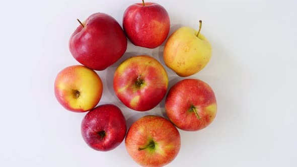 Top View, Beautiful, Red Juicy Apples Laid Out in Shape of Circle, Spinning on White Background