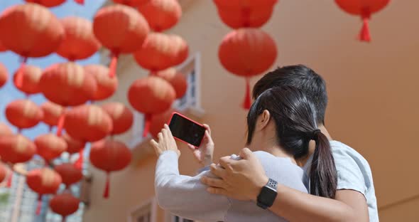 Couple look at the chinese red lantern together at the street