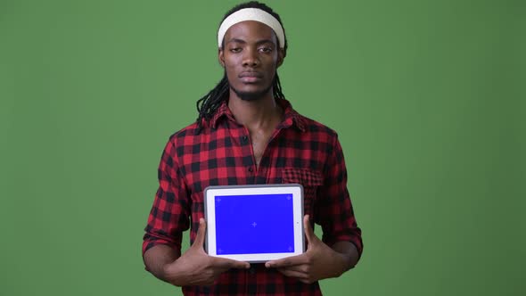 Young Handsome African Man with Dreadlocks Against Green Background