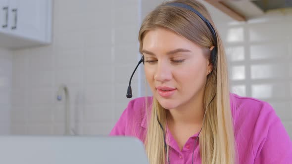 Online tech support specialist wearing headset talking to client on laptop web camera in 4k video