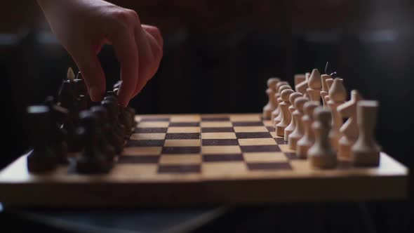 Closeup Side View of Black Pieces Making Move First in Chess Game