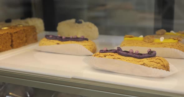 Woman Putting Readymade Eclairs on the Shop Window