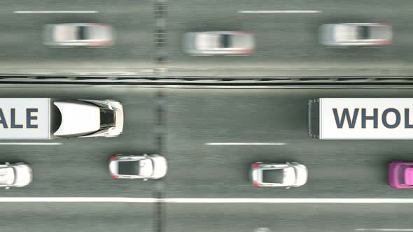 Trailer Trucks with WHOLESALE Text Driving Along the Highway alt