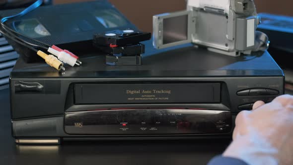 Closeup of Man Ejecting Tape From VHS Player