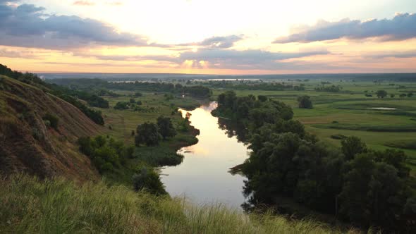 Panoramic View of River Between Fields During Sundown.