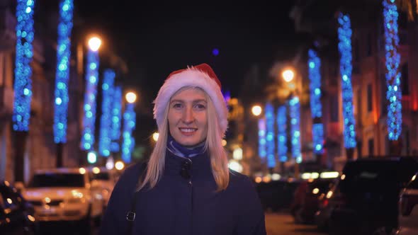 Portrait of a woman smiling at the camera and playing in a Santa hat