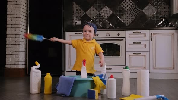 Close-up of a Small Four-year-old Girl Playing in the Kitchen with Detergents.