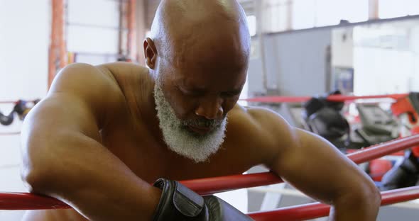 Senior boxer leaning on the boxing ring 4k