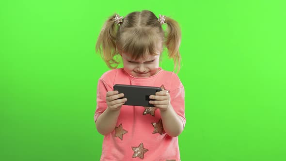 Little Girl Using Smartphone. Portrait of Child with Smartphone Texting, Playing