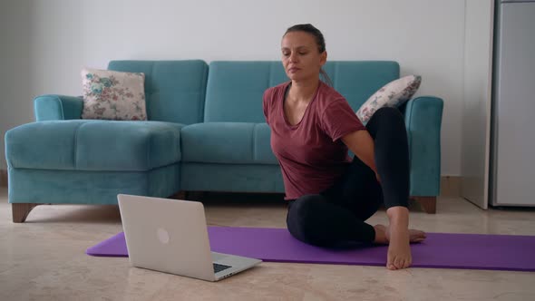 Attractive Young Woman Doing Yoga Stretching Yoga Online at Home.