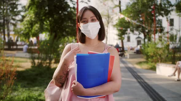 Portrait of happy teacher wearing protective mask in campus university park.