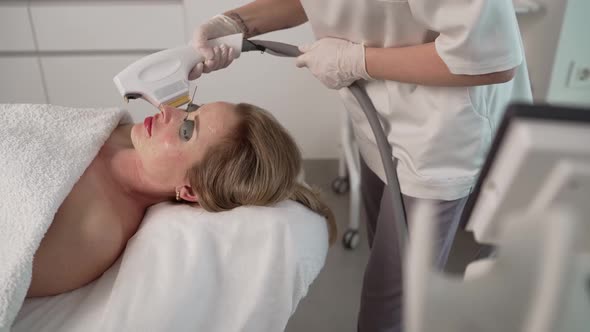 Not a Young Woman is Receiving Facial Treatments in a Beauty Clinic