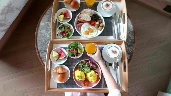 From Above of Woman Hands Take Glass of Orange Juice Breakfast in Hotel