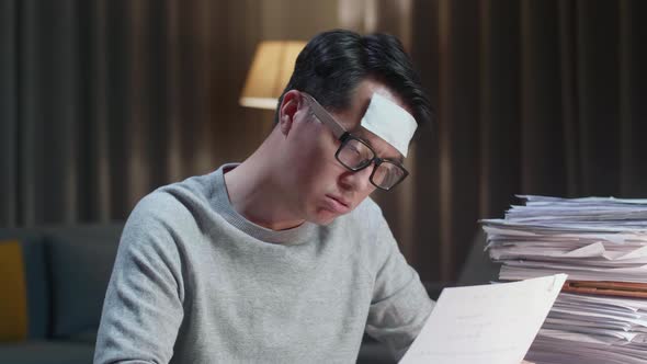 Close Up Of Sick Asian Man Tried While Working Hard With Documents At The Home