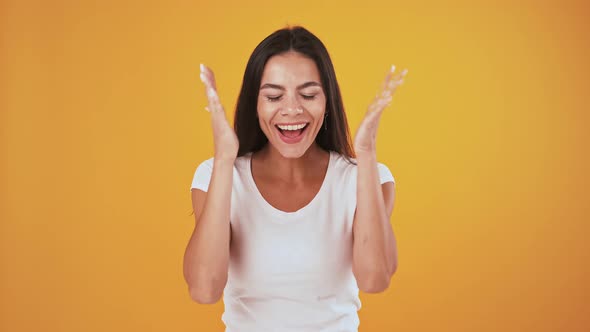 Surprised and Overjoyed Woman is Saying Wow Smiling Posing on Orange Background