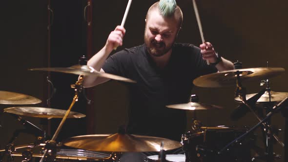 Drummer performing in a studio setting.