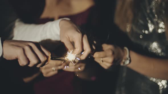 Hands or Palms on Black Background Seting Fire To Sparklers with Lighter or Fire, Holding and Waving