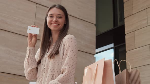 Woman Posing with Credit Card Outside