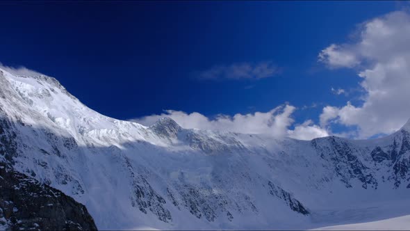 Timelapse of the Two Peaks of the Russian Mountain Belukha in the Clouds Floating in the Sky