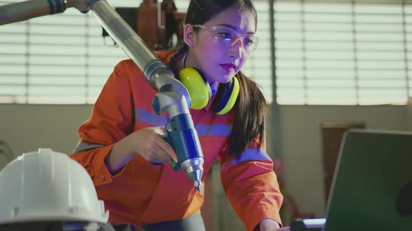 asian female engineer specialist with Measuring machine with a manipulator arm.