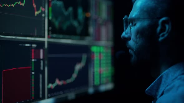 Trader is Working with Multiple Computer Screens with Charts and Data Analysis and Stock Broker