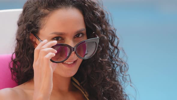 Headshot Portrait of Happy Cheerful Curly Hispanic Girl Student Takes Off Sunglasses Looks at Camera