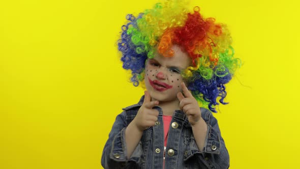 Little Child Girl Clown in Rainbow Wig Making Silly Faces. Having Fun, Smiling, Dancing. Halloween