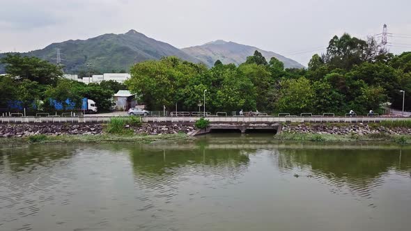 A dynamic horizontal aerial footage of a river near Yuen Long, Hong Kong. This shot showcases the mo