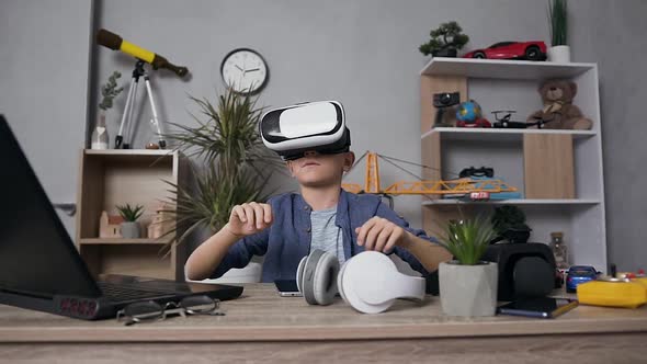 12-Aged Boy in Blue Shirt which Wearing Augmented Reality Glasses During Playing Video Game