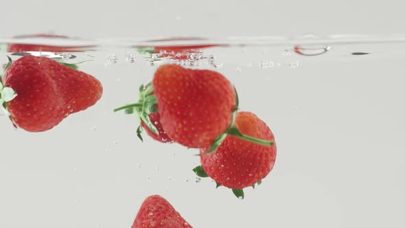 Fresh Strawberry Fruit Dropped Into Water Shot in Super Slow Motion